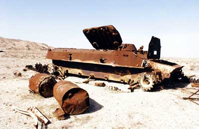 クウェート国境そばの非武装地帯に、放置されたままのイラ ク軍戦車の残がい。側面の２ヵ所に劣化ウラン弾の貫通痕が残る （２０００年１月、イラク・サフワン市近郊）